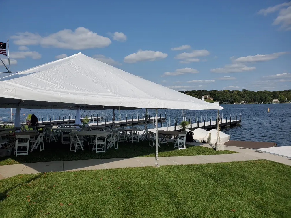 A large tent on a sunny day, the seating underneath the tent is in the shade.