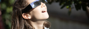 Surprised girl watching a solar eclipse of the sun with eclipse glasses