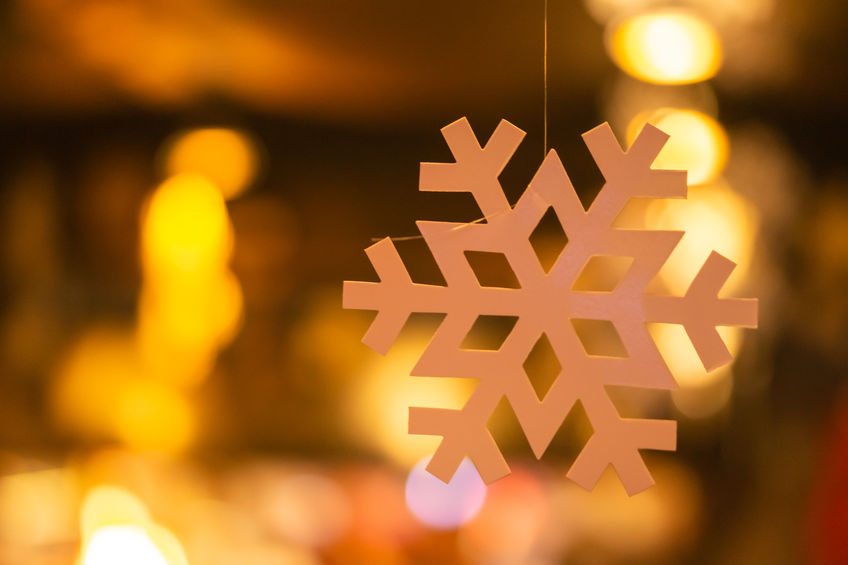 Decorative snowflake on the background of garland lights