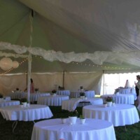 Wedding tables under a tent rented from Big T Tents.